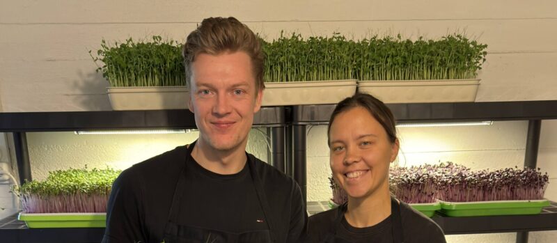 Mann og kvinne smiler og holder mikrogrønnsaker.